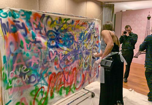 woman spraying onto canvas