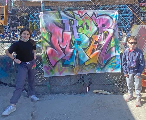 2 kids posing with an artwork canvas