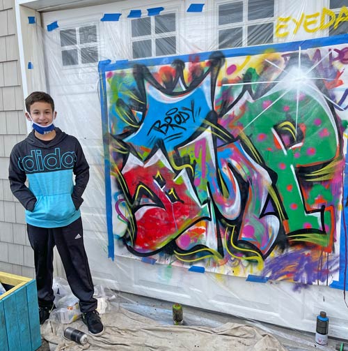 boy posing with large canvas artwork