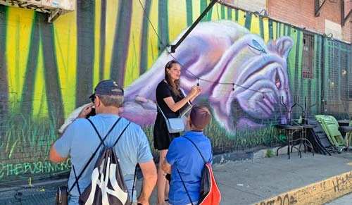 People standing in front of mural artwork